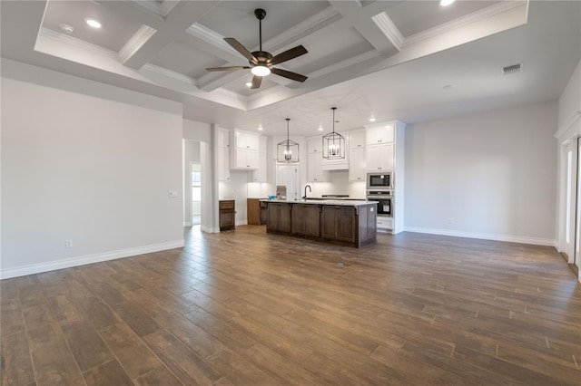 kitchen featuring pendant lighting, an island with sink, stainless steel appliances, white cabinets, and coffered ceiling