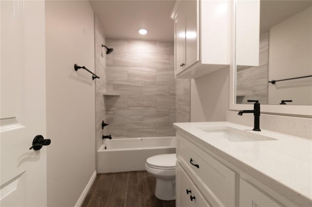 full bathroom with toilet, vanity, and tiled shower / bath