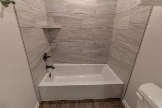 bathroom with toilet, hardwood / wood-style flooring, and tub / shower combination