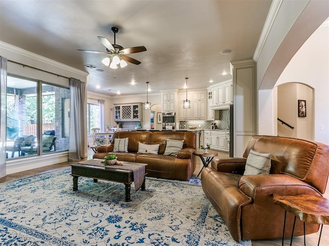 living room featuring ceiling fan and ornamental molding