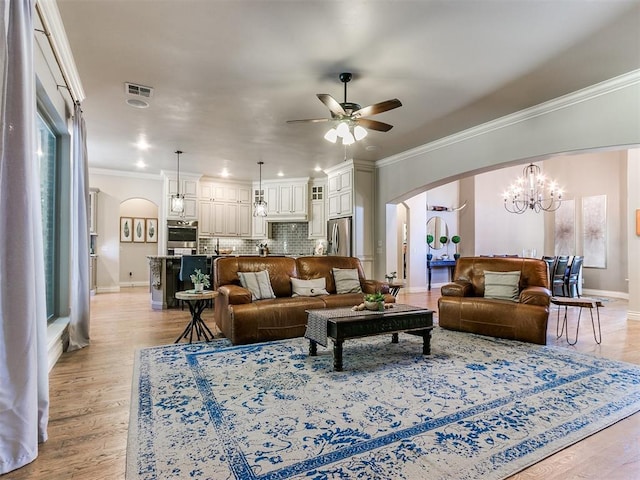 living room featuring crown molding, light hardwood / wood-style floors, and ceiling fan with notable chandelier