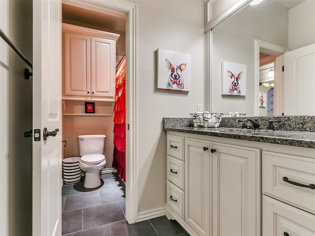 bathroom featuring tile patterned flooring, vanity, and toilet