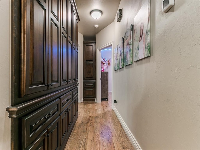 hallway with light hardwood / wood-style floors