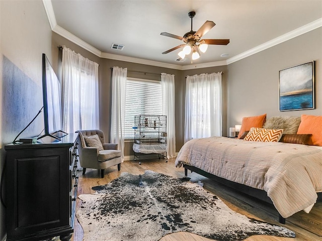 bedroom featuring light hardwood / wood-style flooring, ceiling fan, and crown molding