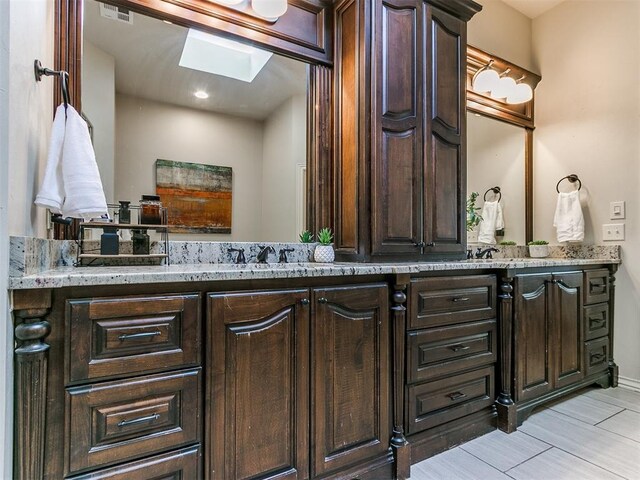 bathroom featuring vanity and a skylight