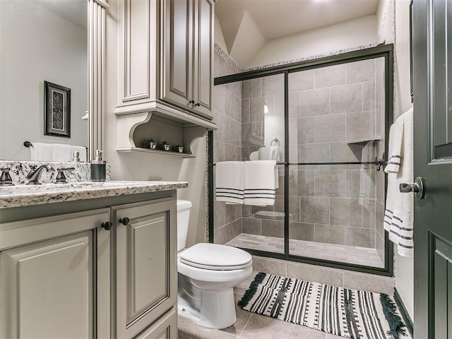 bathroom with toilet, vanity, tile patterned floors, and an enclosed shower