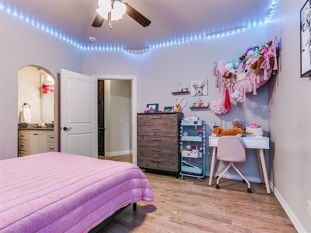 bedroom with light hardwood / wood-style flooring, ensuite bath, and ceiling fan