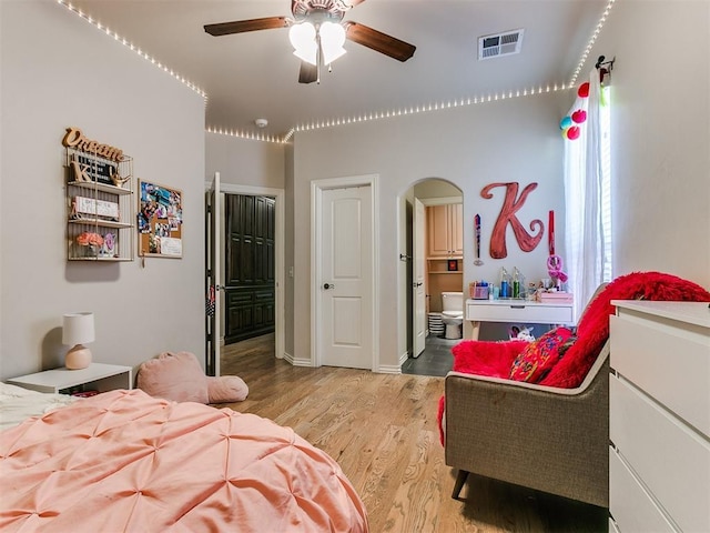 bedroom featuring ceiling fan, connected bathroom, and light hardwood / wood-style flooring