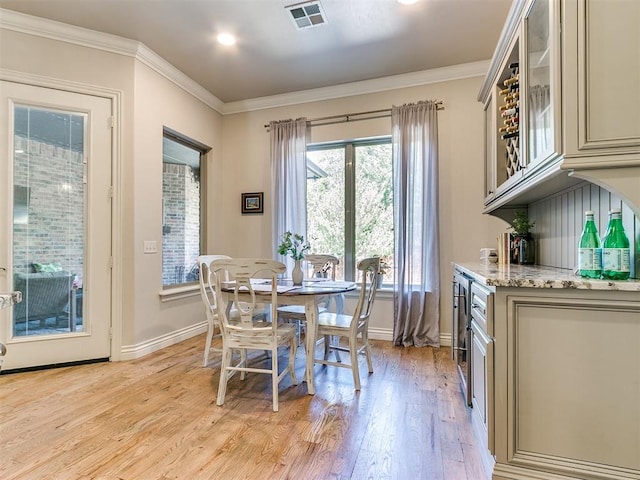 dining area featuring light hardwood / wood-style floors and crown molding