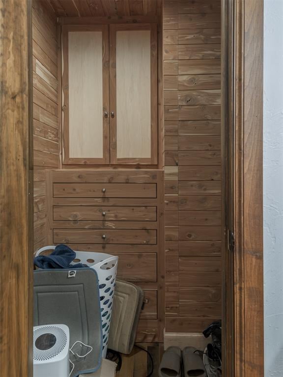 washroom featuring wood ceiling and wood walls