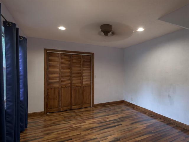 unfurnished bedroom featuring ceiling fan, dark hardwood / wood-style flooring, and a closet