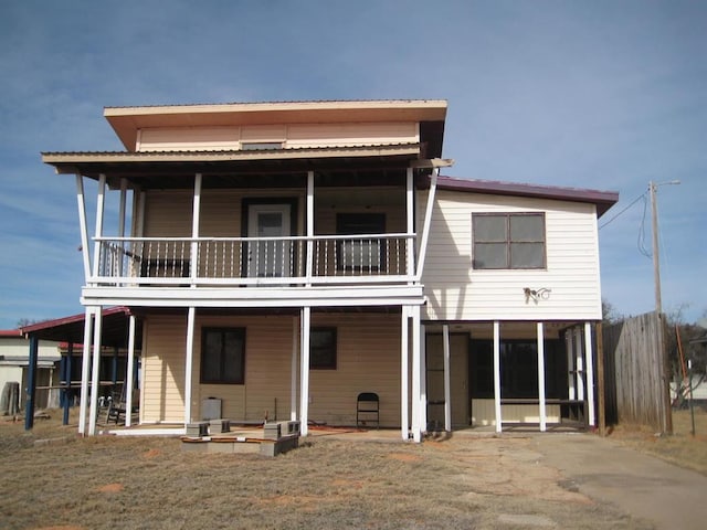 rear view of property featuring a carport and a balcony