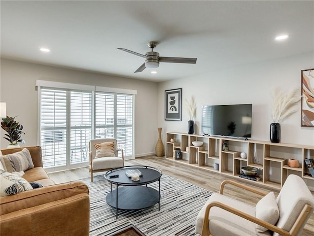 living room featuring light wood-type flooring and ceiling fan