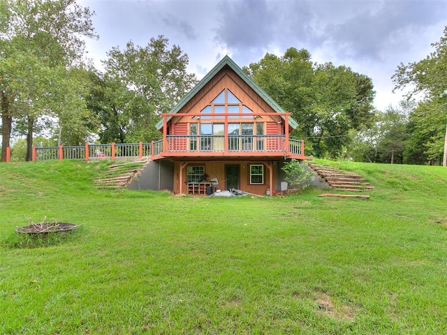 rear view of property with a wooden deck and a lawn