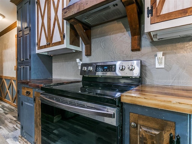 kitchen with butcher block countertops, stainless steel electric range oven, extractor fan, and light hardwood / wood-style flooring