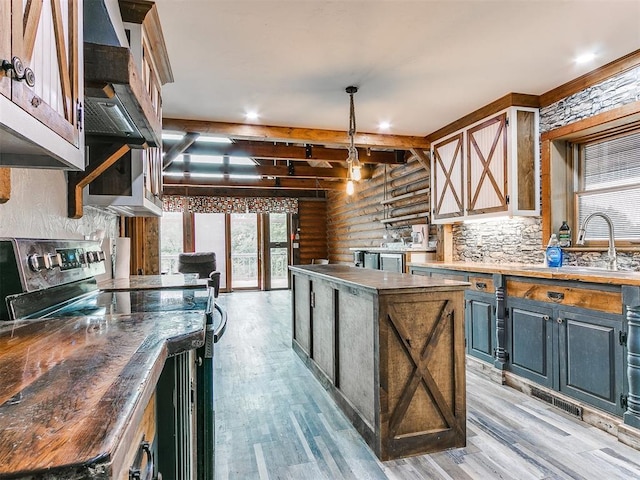 kitchen featuring electric range, a large island, light wood-type flooring, and sink