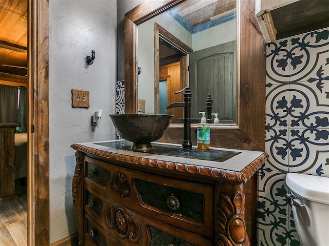 bathroom featuring vanity, hardwood / wood-style flooring, toilet, and crown molding