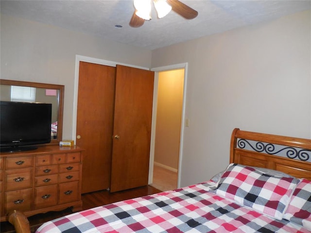 bedroom with ceiling fan, dark hardwood / wood-style flooring, and a closet