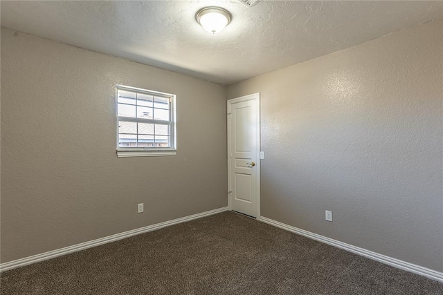 carpeted empty room featuring a textured ceiling