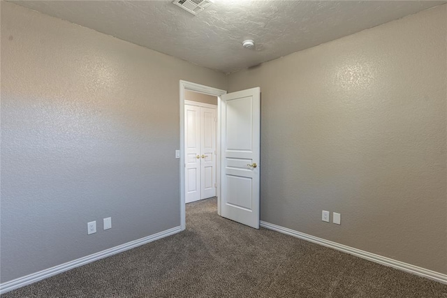 carpeted spare room featuring a textured ceiling