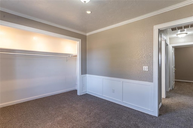 unfurnished bedroom featuring dark colored carpet, a textured ceiling, a closet, and ornamental molding