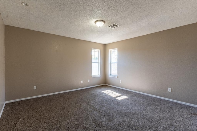 spare room featuring carpet flooring and a textured ceiling