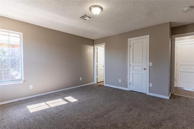 unfurnished bedroom featuring dark colored carpet and a textured ceiling