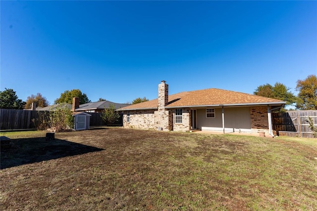 view of front of home with a storage shed and a front lawn