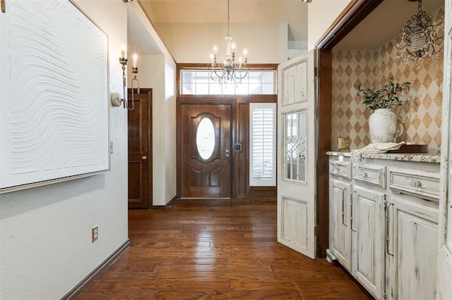 foyer with dark hardwood / wood-style flooring and an inviting chandelier