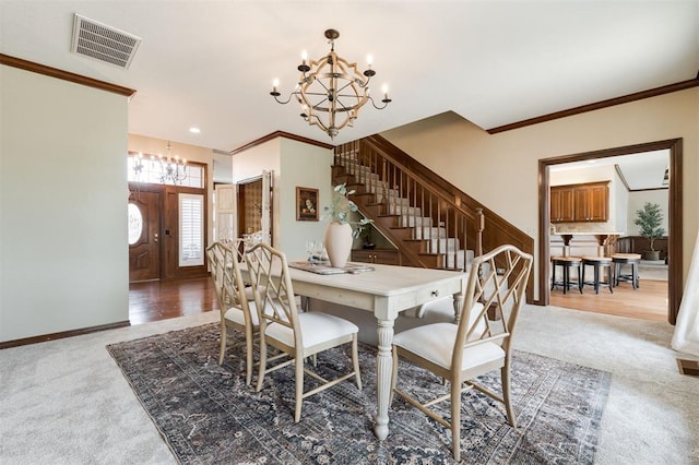 carpeted dining room with crown molding and a notable chandelier