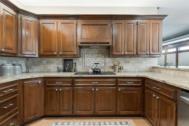 kitchen with stainless steel dishwasher, light stone countertops, and tasteful backsplash