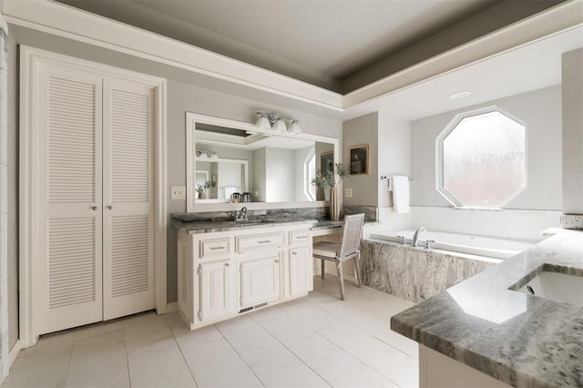 bathroom with vanity, a relaxing tiled tub, tile patterned floors, and a tray ceiling