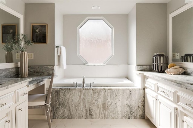 bathroom featuring vanity and tiled bath