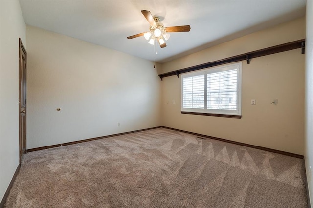 carpeted spare room featuring ceiling fan