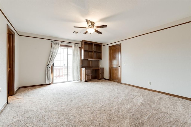 interior space featuring ceiling fan, light colored carpet, and ornamental molding