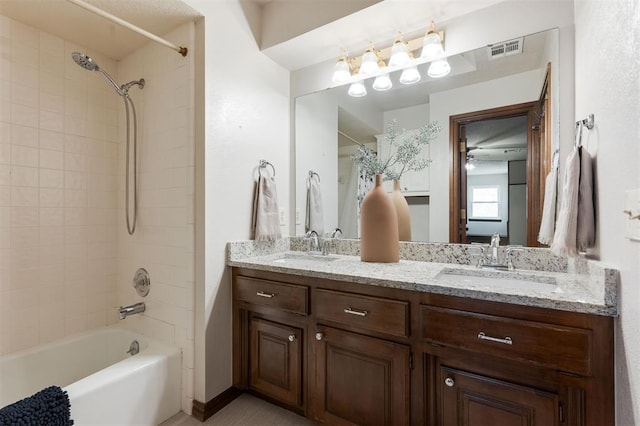 bathroom with vanity, tiled shower / bath combo, and ceiling fan