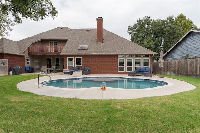 view of pool with a lawn, a patio area, a grill, and an outdoor hangout area