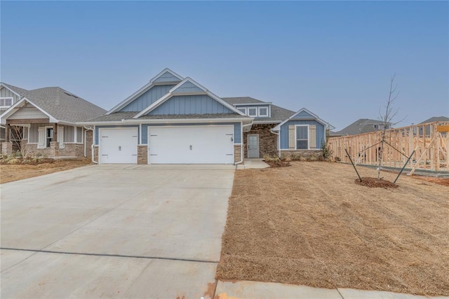 craftsman inspired home featuring board and batten siding, driveway, a garage, and fence