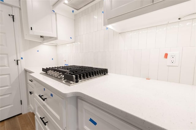 kitchen featuring white cabinetry, stainless steel gas cooktop, decorative backsplash, and wood finished floors