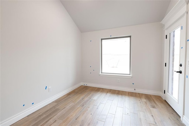 unfurnished room with lofted ceiling, baseboards, and light wood-style floors