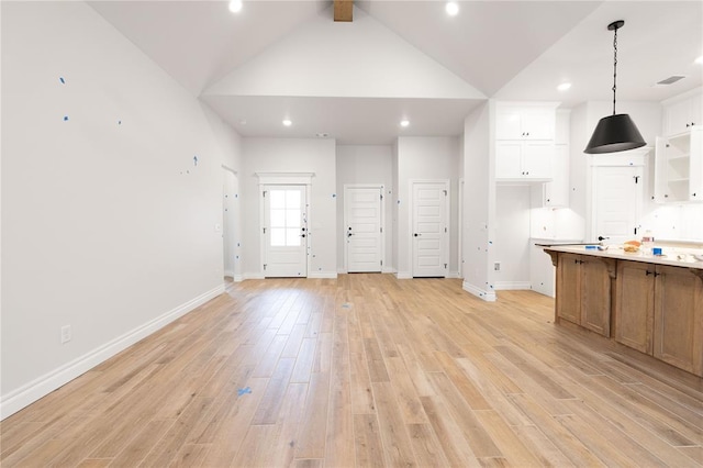 kitchen with light wood finished floors, baseboards, white cabinetry, and light countertops