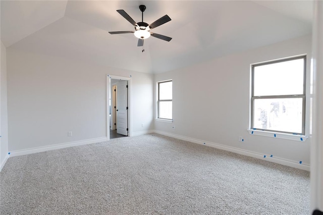 empty room with ceiling fan, baseboards, vaulted ceiling, and carpet flooring