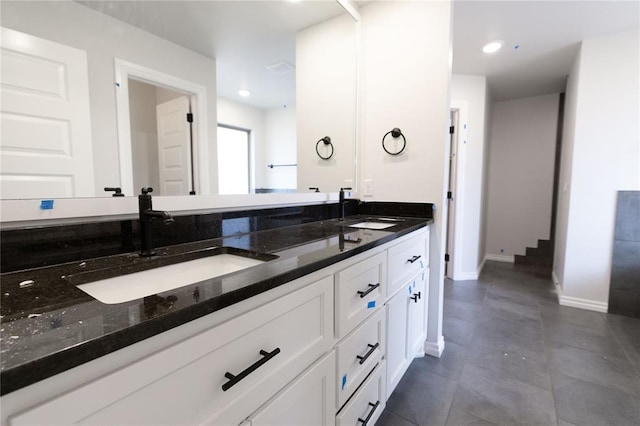 full bathroom with double vanity, baseboards, a sink, and recessed lighting