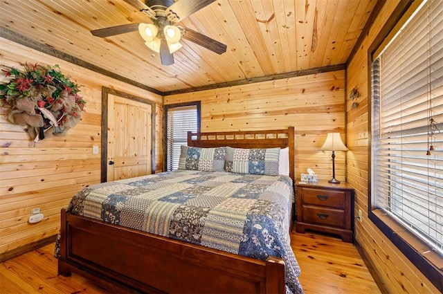 bedroom with wooden ceiling, light hardwood / wood-style flooring, ceiling fan, and wooden walls