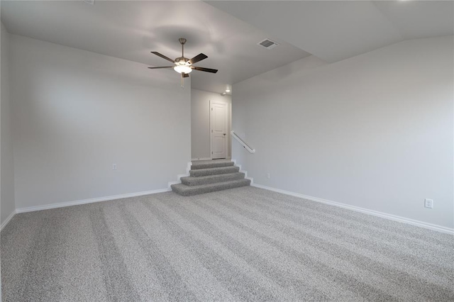 carpeted spare room featuring vaulted ceiling and ceiling fan