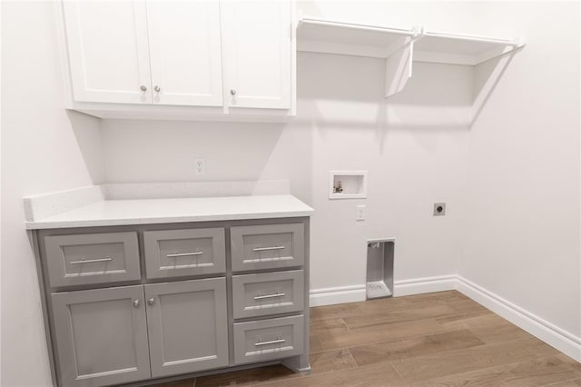 laundry area featuring cabinets, hookup for a washing machine, hookup for an electric dryer, and light hardwood / wood-style flooring