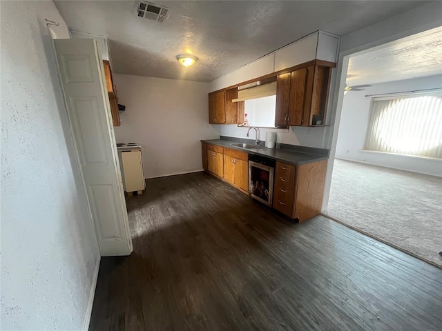 kitchen with dark hardwood / wood-style flooring, ceiling fan, beverage cooler, sink, and range