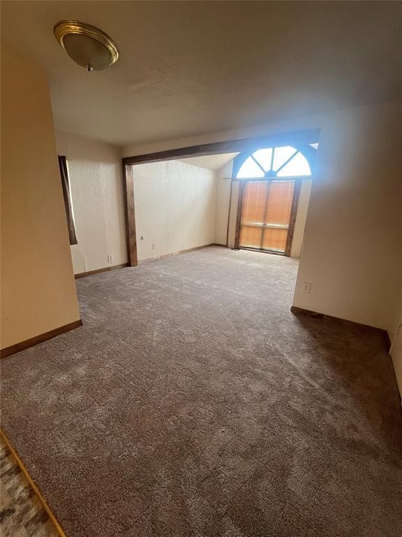 spare room with dark carpet