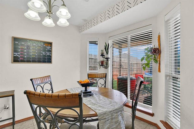 tiled dining room with a chandelier