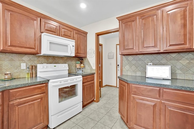 kitchen with tasteful backsplash, light tile patterned flooring, and white appliances